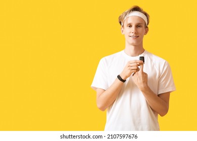 Sporty young man with pulse oximeter on color background