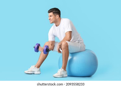 Sporty young man training with dumbbell on color background - Shutterstock ID 2093558233