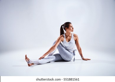 Sportliche junge Frau, die Yoga-Übungen einzeln auf weißem Hintergrund - Konzept des gesunden Lebens und des natürlichen Gleichgewichts zwischen Körper und mentaler Entwicklung