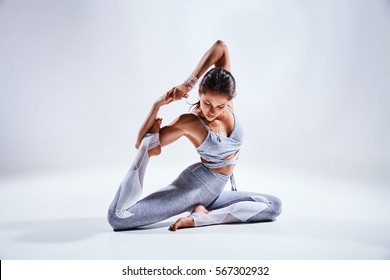 Sporty young woman doing yoga practice isolated on white background - concept of healthy life and natural balance between body and mental development