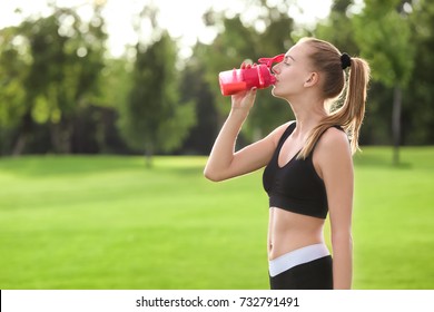 Sporty Young Woman Drinking Protein Shake Outdoors