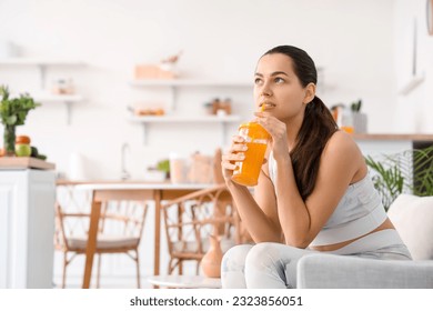 Sporty young woman drinking vegetable juice in kitchen - Shutterstock ID 2323856051