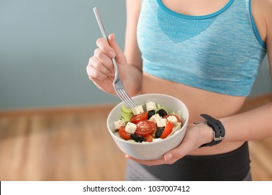 Sporty Young Woman Eating Salad After Fitness Training At Home