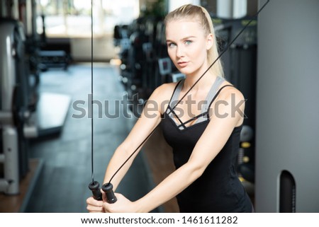 
Sporty young woman in the gym is doing a chest exercise