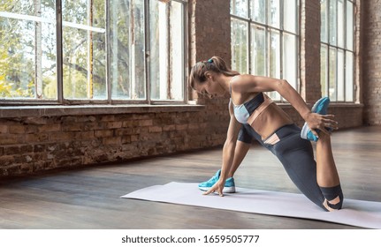 Sporty Young Woman Hatha Yoga Fitness Instructor Warmup Bend Knee Stretch Leg Hip Do Crescent Lunge Exercise Twisted Monkey Anjaneyasana Pose Gym Studio Workout Health Lifestyle Concept Copy Space.