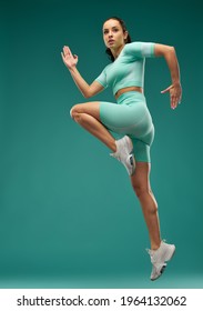 Sporty young woman jumping in the air - Shutterstock ID 1964132062