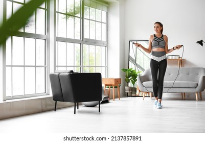 Sporty Young Woman Jumping Rope At Home