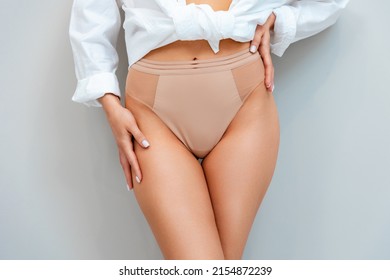 A Sporty Young Woman In Lingerie And A White Shirt Poses On A Gray Background. Close Up. The Concept Of Removal Hair.