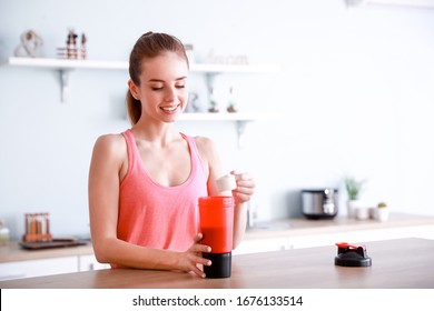 Sporty Young Woman Making Protein Shake At Home