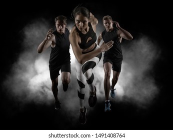 Sporty young woman and men running on black background - Powered by Shutterstock