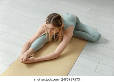 Sporty young woman practicing yoga on light floor at home - Powered by Shutterstock