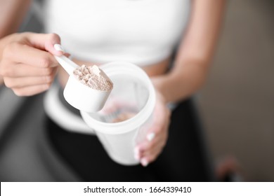 Sporty young woman with protein at home, closeup - Shutterstock ID 1664339410