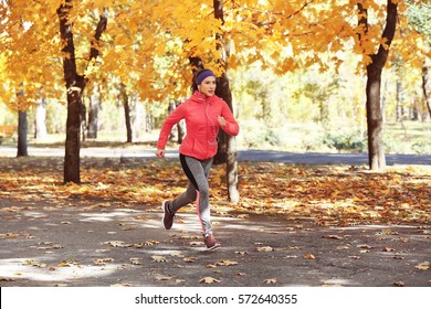 Sporty Young Woman Running In Autumn Park