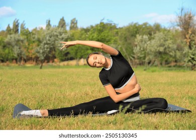 Sporty young woman stretching in park - Powered by Shutterstock