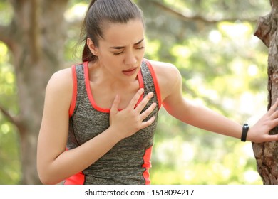 Sporty Young Woman Suffering From Heart Attack Outdoors