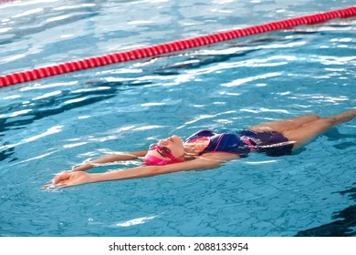 Sporty young woman swimming in pool - Powered by Shutterstock