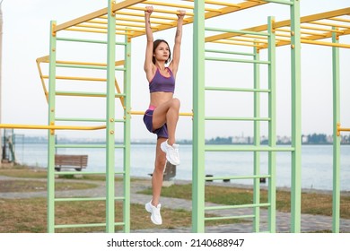 Sporty young woman training on monkey bars outdoors - Powered by Shutterstock