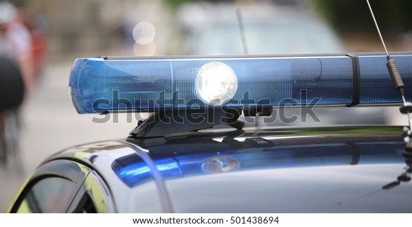 spot light and blue flashing lights of the police\
car in the city