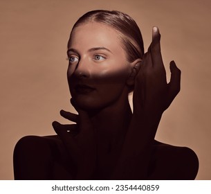 Spotlight, face or woman in shadow with beauty and creative aesthetic in studio background. Light on eyes, person or elegant model with dark side, art or style thinking of skincare, glow or cosmetics - Powered by Shutterstock