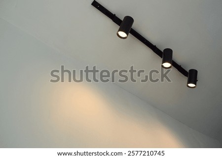 Spotlights under the ceiling on the wall. LED track lighting system. Black interior spotlights