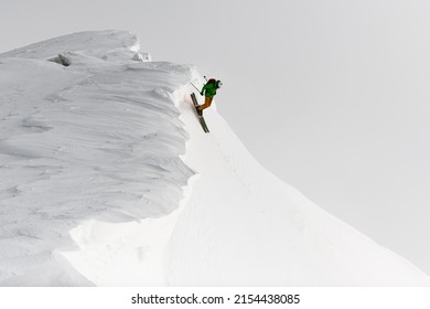 Spotrsman splitboard freerider rides down from top of ridge. Ski touring in mountains, winter freeride extreme sport