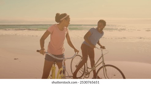 Spots of light against african american couple riding bicycles together at the beach. pedal day awareness concept - Powered by Shutterstock