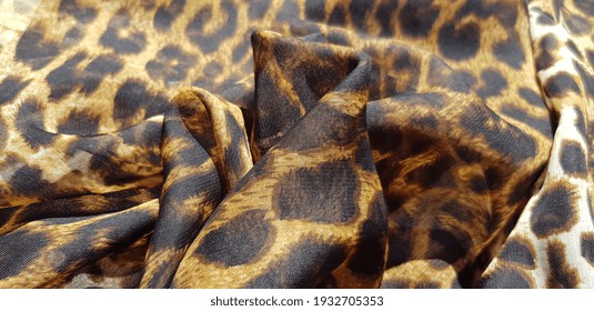 Spotted translucent fabric with leopard print, in folds (texture).