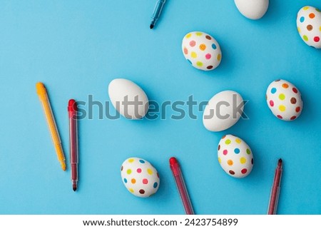 Spotty painted colorful easter eggs on blue background. Directly above table top shot.