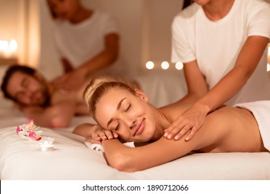 Spouses Relaxing During Massage And Aromatherapy Lying Together On Beds At Luxury Spa Resort, With Eyes Closed. Relaxation Treatment And Body Care Concept. Selective Focus