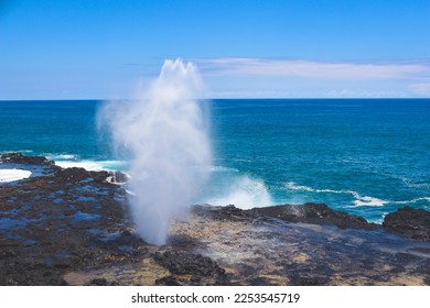 Spouting Horn blowhole against bright blue tropical ocean in Kauai, Hawaii