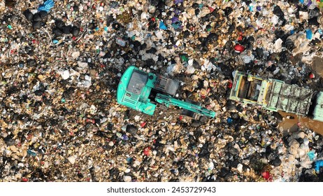 A sprawling landfill stretches into the horizon. An aquamarine excavator shifts through the mound, while a truck awaits its load. The chaos below epitomizes the vastness of waste management. Drone.
 - Powered by Shutterstock