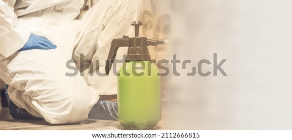 Spray\
bottle with pesticides close-up. An exterminator in work clothes\
sprays pesticides from a spray bottle. Fight against insects in\
apartments and houses. Disinsection of\
premises.