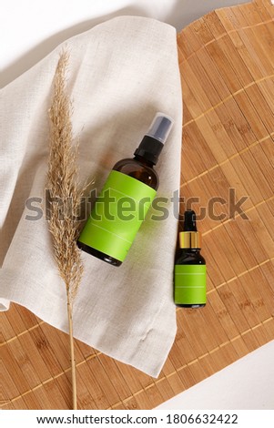 Spray bottles with cosmetic products and green space for your brand on bamboo mat background. Concept of cluelty free, organic, kosher cosmetic online shop and advertisment.