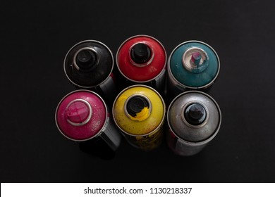 Spray Paint Cans Top Down On Black Background