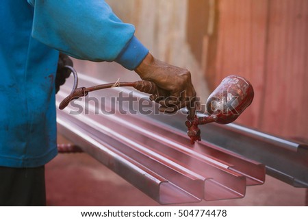 Spray painting red color to the steel by the worker