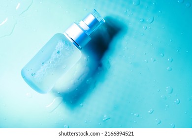 Spray Transparent Bottle Over Blue Background, Cosmetics Or Body Care Product. High Quality Photo