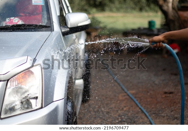 Spray water on the car\
to clean the car.