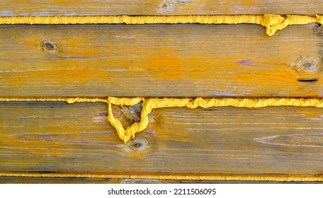 Sprayed And Hardened Polyurethane Foam From A Cylinder On The Wall Of The Future Cottage. Wood And Foam, Uneven Seam. Construction And Isolation Concept.