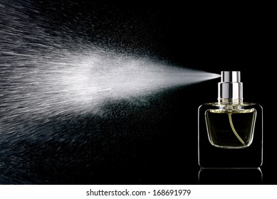 Spraying perfume bottle glass on a black background isolated - Shutterstock ID 168691979
