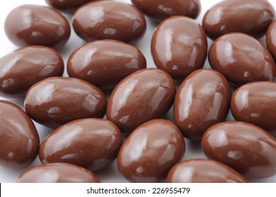 Spread Of Chocolate Covered Almonds On White Background