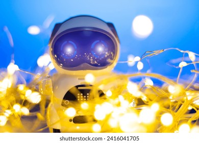 Spread and Development Artificial Intelligence in New Year. Small real robot with garlands on blue background. Modern digital technology concept. Ukraine flag colours.