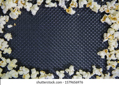 spread popcorn in a frame shape on a textured black background