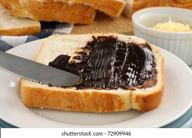 Spreading The Iconic Australian Spread Vegemite On To A Slice Of Fresh Bread.