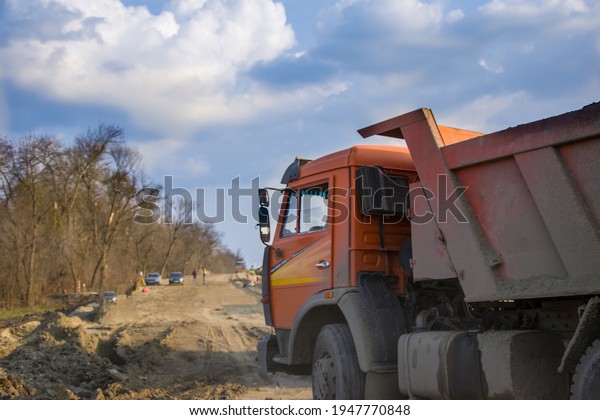 Spring\
2021, Russia, Krasnodar. Loaded KAMAZ in the process of work. The\
truck is carrying construction materials for road repairs. Road\
works are underway everywhere. Editorial\
license