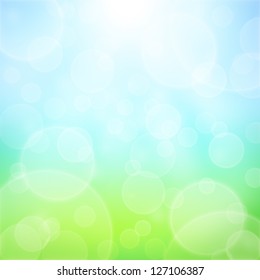 Spring abstract background with bokeh and sun rays. Grass and blue sky