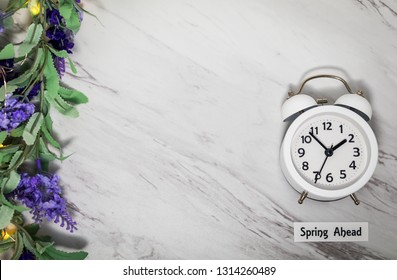 Spring Ahead Daylight Saving Time Concept On Gray Marble With White Clock And Flowers, Flat Lay 