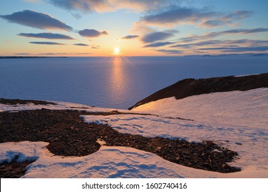 Spring Arctic Landscape With The Midnight Sun And The Coast Of The Arctic Ocean. North Of The Arctic Circle At The End Of May, The Sun Does Not Set At Night Over The Horizon. Pevek, Chukotka, Russia.