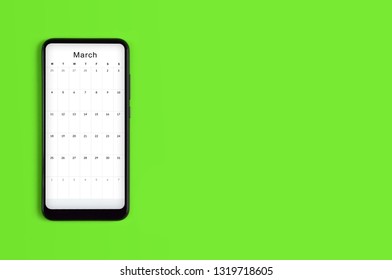 Spring background with smartphone. Flat lay. Copy space. Spring has come. The concept spring. Concept spring background for designer. Calendar in the smartphone.