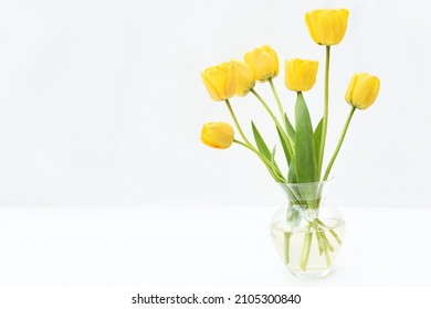 Spring blossoming tulips, yellow flowers posy on light background, bright floral card, selective focus, shallow DOF, toned