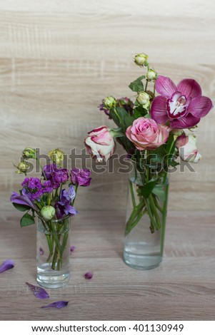 spring bouquet of flowers in a glass vase rose pink orchid on a wooden background